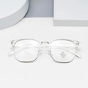 Closeup of clear multi-sided fashion eyeglasses frame with silver metal bridge and blue light lens.
