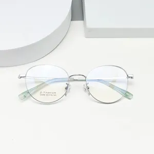 Detail view of minimalist round beta-titanium eyeglasses frame in silver, high quality.