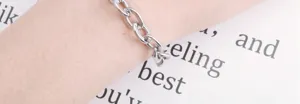 Gedetailleerde opname van een stijlvolle schakelarmband van metaal om de arm, veelzijdig accessoire.