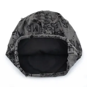 Gros plan d'un bonnet slouchy gris effet usé avec des imprimés de lettres anglaises tendance.