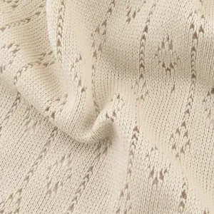 Close-up detail view of breathable hollow-out knit fabric, soft texture for summer hat.