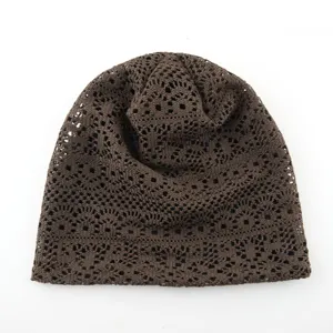 Close-up detail of the brown crochet slouchy beanie showing hollow-out knit pattern and texture.