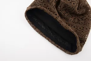 Closeup of brown knit hollow beanie detail, highlighting breathable mesh inner lining.