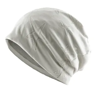 Gros plan sur le bonnet slouchy blanc avec motif d'étoiles, tissu doux et confortable.