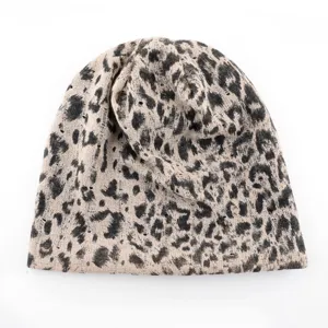 Gros plan de la texture du bonnet en tricot imprimé léopard, montrant les détails du tissu.