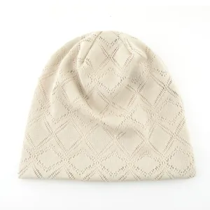 Gros plan du bonnet en tricot beige, détail de motif en losanges respirant pour femmes.