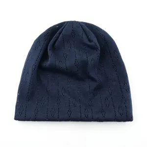 Dark blue hollow knitted beanie detail, lightweight breathable summer cap texture close up.