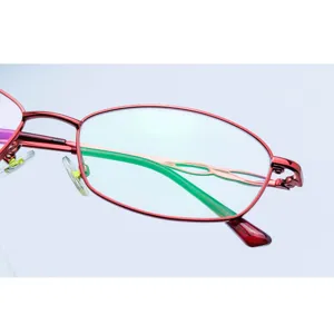 Red metal full frame glasses for women, classic oval optical eyewear frame close-up shot.