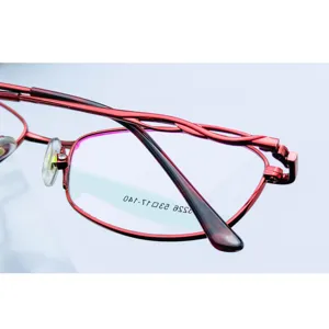 Trendy women's business metal full frame eyeglasses with stylish twisted red temples.