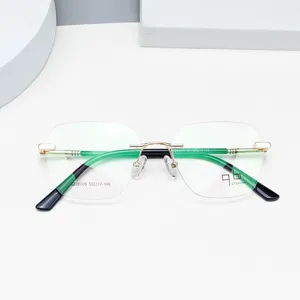 Detailansicht der leichten rahmenlosen optischen Brille mit goldener Metallbrücke und grünen Bügeln.