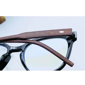 Vue de détail d'une élégante monture de lunettes ovale TR90 effet bois avec bord noir.