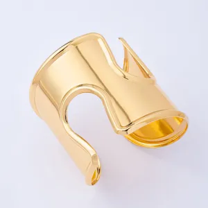 Bracciale polsino largo in metallo dorato con design intagliato, gioiello da braccio alla moda.