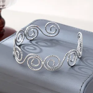 Bracciale rigido aperto con spirale geometrica argentata, gioiello da braccio vintage.