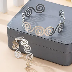 Primo piano del set di bracciali rigidi a spirale geometrica in tonalità argento.