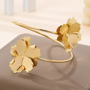 Elegante gouden armband met meerdere bloemlagen open armklem, vintage chic detail.