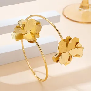 Gedetailleerd overzicht van de elegante gouden armband met prachtige gestructureerde bloemen.