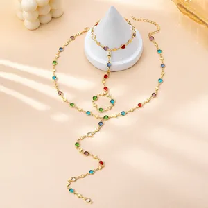 Precioso detalle de joyería dorada con pedrería multicolor y elegante diseño de cadena.