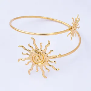 Gouden zon bovenarm manchet detail, geometrische metalen open armband, elegante vintage stijl.