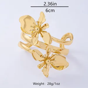 Elegantes goldenes Metall Blumen Armreif Detail, modischer Damenschmuck für den Alltag.