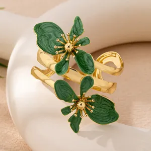 Goldfarbenes Armband mit tiefgrünen Emaillblüten-Details, elegante Nahaufnahme.