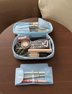 Vista detallada de la bonita bolsa de cosméticos azul con brochas de maquillaje ordenadas.