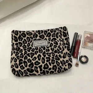 Close-up detail of the stylish leopard print cosmetic pouch, showing the retro woven label.