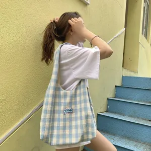 Casual blue and white plaid canvas shoulder bag detail view in daily street style scene