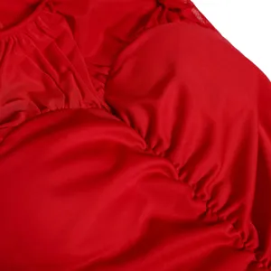 Detalle de tela roja fruncida para disfraz de mujer, material elástico con corsé texturizado.