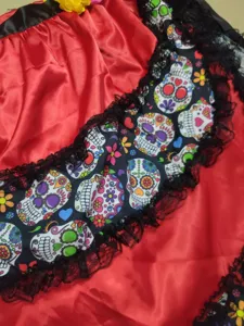 Close up of Halloween skull skirt fabric, red satin with black lace and colorful sugar skulls.