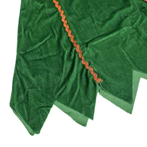 Green velvet costume detail with zigzag hem and orange wave trim for festive holiday apparel.