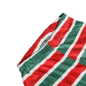 Close-up detail shot of Christmas striped pants waistband, red green white elastic fabric.