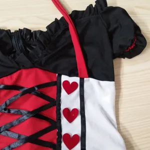 Détail du corset de costume de reine médiéval avec rubans noirs et cœurs rouges.