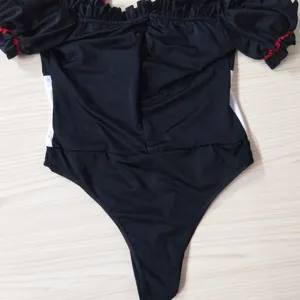 Vue détaillée du body costume de reine médiévale avec épaules dénudées et volants.