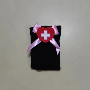 Vista dettagliata di eleganti calze da infermiera cosplay nere con fiocco rosa e toppa cuore.