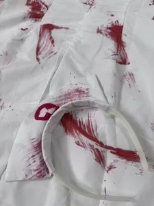Vista detallada del disfraz de enfermera zombi de Halloween con diadema ensangrentada.