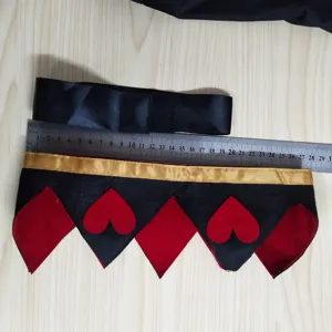 Détail accessoire costume reine, couronne noire et rouge avec motifs cœurs et mesure.