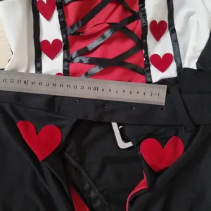 Gros plan détaillé du costume de la Reine de Cœurs avec décors de cœurs rouges et laçage.