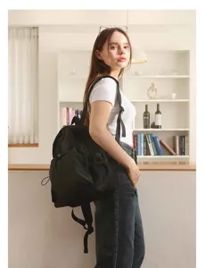 Detailansicht des grauen Rucksacks mit Kordelzug und praktischen Netztaschen an den Seiten.