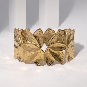 Close-up view of gold stainless steel floral cuff bracelet, elegant open wristband