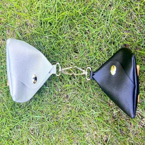 Detailansicht der tragbaren doppelten Golfballtasche mit praktischem Metallhaken im Gras.