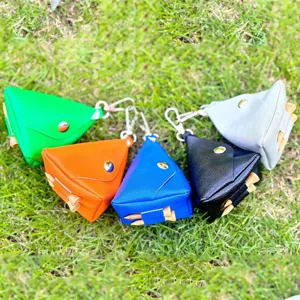 Details des tragbaren Dreieck-Golfballbeutels mit Tees und Haken im grünen Gras.