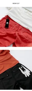 Golfbekleidung Set mit Totenkopf Logo Anhänger, rote Hose und weißes Oberteil Detailaufnahme.