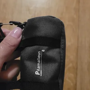 Piccola custodia per palline da golf nera in poliestere resistente con gancio.
