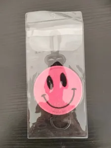 Gedetailleerd overzicht van het roze smiley golfbaltasje met zwart geborduurd gezicht en haak.