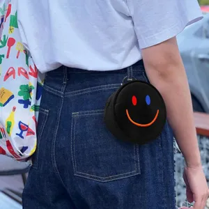 Bolso redondo portátil para pelota de golf en negro con cara sonriente bordada para la cintura.