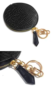 Detailed view of black crocodile pattern leather round coin purse and mini earphone bag keychain.