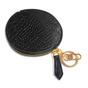 Black leather round coin purse with crocodile pattern and golden keychain hook for use.
