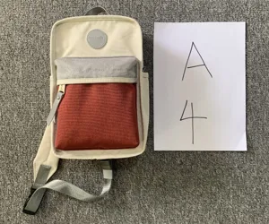 Detailansicht des Himawari Farbblock Canvas Sling Rucksacks in Creme, Grau und Rot.