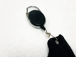 Nahaufnahme der schwarzen Golfhandtuch-Details mit einziehbarer Karabinerhaken-Rolle.