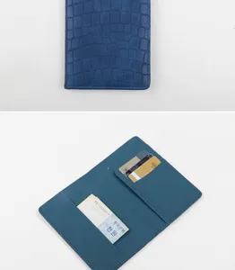 Vista dettagliata del porta passaporto in pelle PU blu con tasche per carte e banconote.